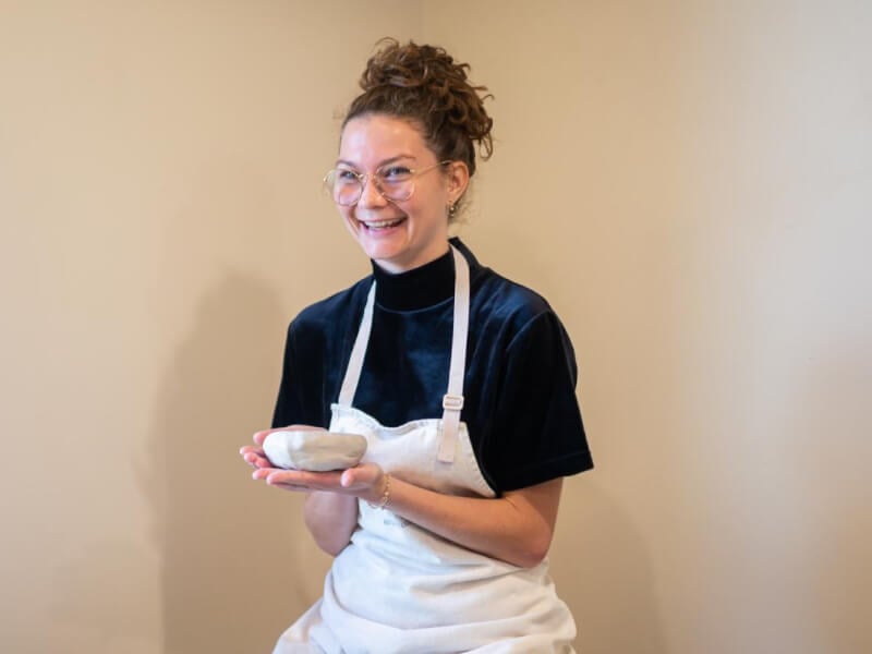 woman smiling with hand building clay